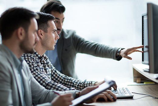 Two coworkers discussing something on a laptop.