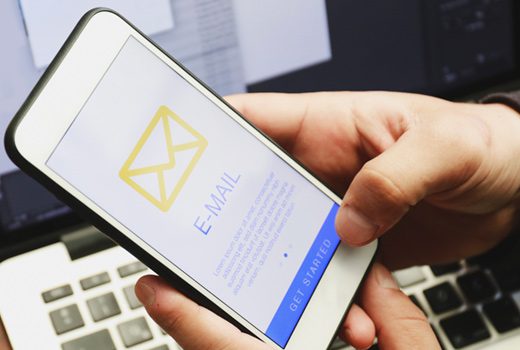 Person holding smartphone with email setup screen displayed.
