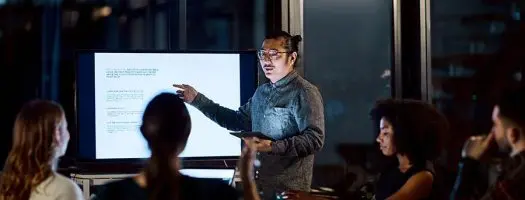 Presenter leading training in corporate boardroom.