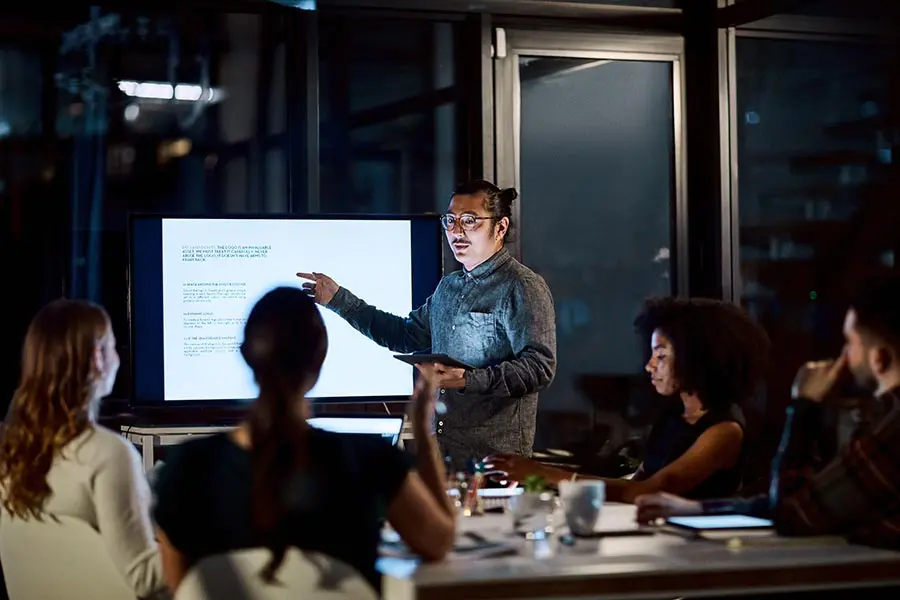 Presenter leading training in corporate boardroom.