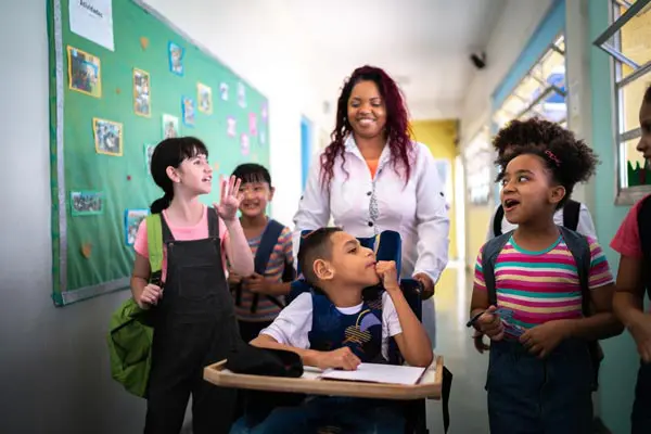 Teacher engaging with young students in a colorful classroom.