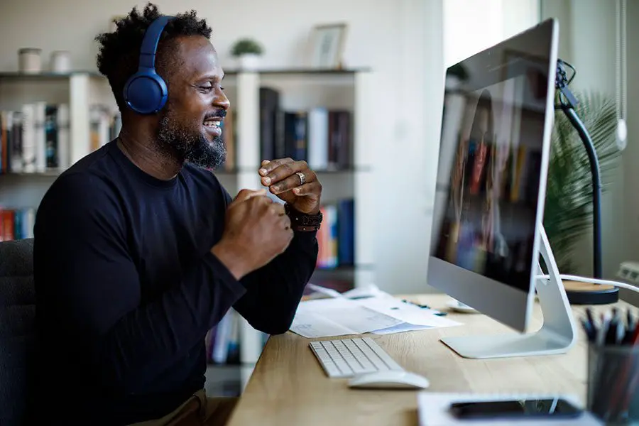 Man enthusiastically speaking in a virtual call on his desktop.