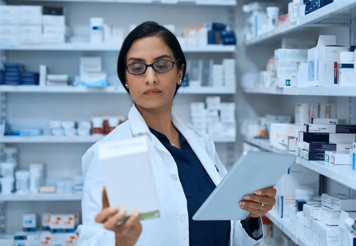Female pharmacist dispensing medication efficiently
