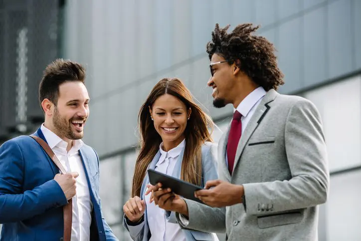 Happy businesspeople walking and talking outdoors (duplicate)