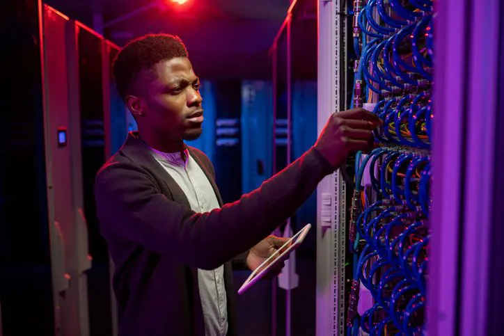 Technician inspecting a server rack in a data center.