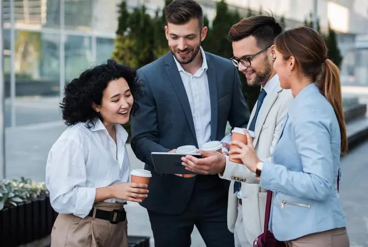 Coworkers discussing business plan outside office building