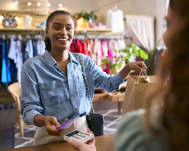 Female customer paying for clothes with contactless card