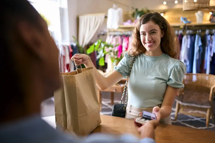 Female customer using mobile app for fashion store payment