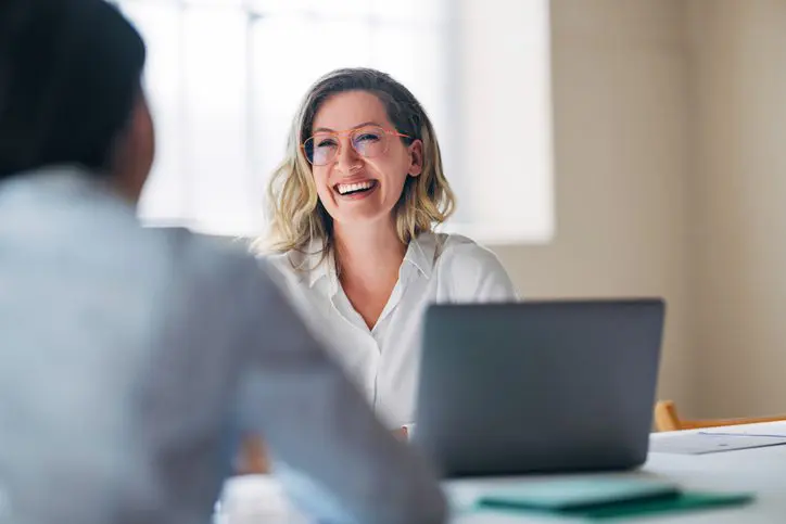Woman smiling during a video call at her laptop.