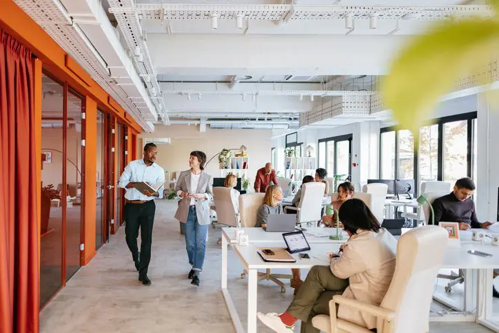 Team members walking through a bright, open-concept office.