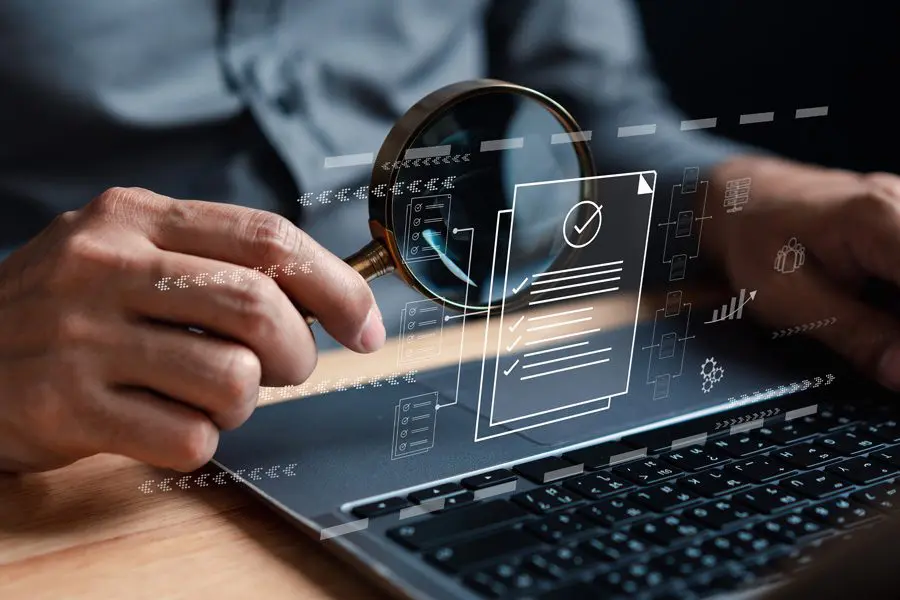 Hands using a laptop with a floating user interface graphic.