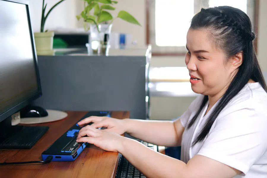 A social woman typing on a keyboard and laughing.