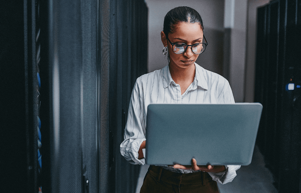 Businesswoman standing in a data center holding a tablet.