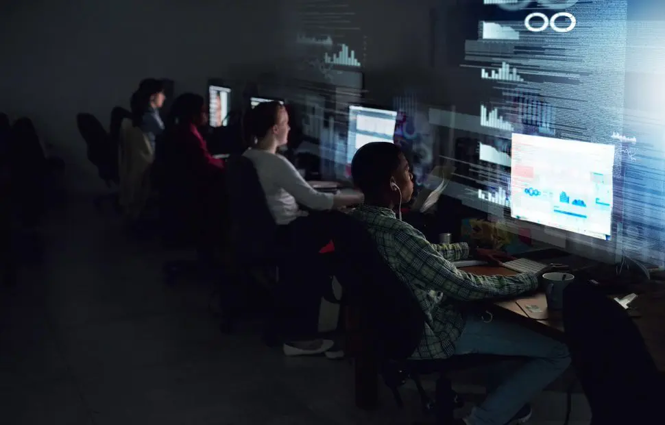 Analysts monitoring data and security systems in a control room.