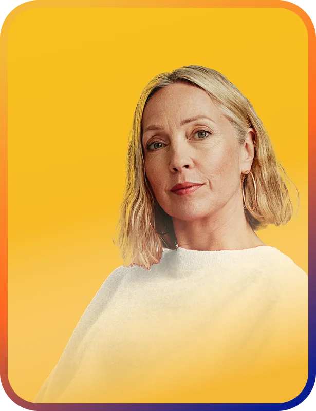 Blonde woman standing in front of a vibrant orange background.